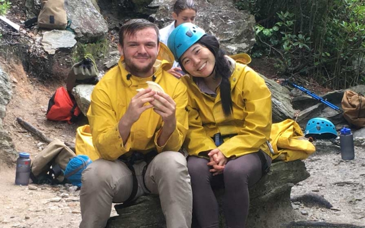 two gap year students rest on a rock on an outward bound expedition in the blue ridge mountains